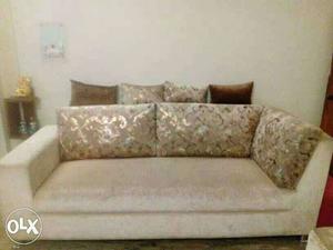 Cream and beige colour three seated sofa with 4 throw away