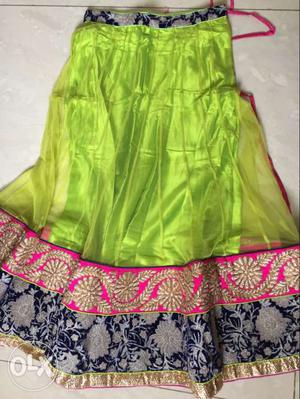 Green lehenga choli with a rich pink border in