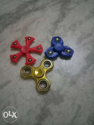 Three Blue, Yellow, And Red Hand Spinners