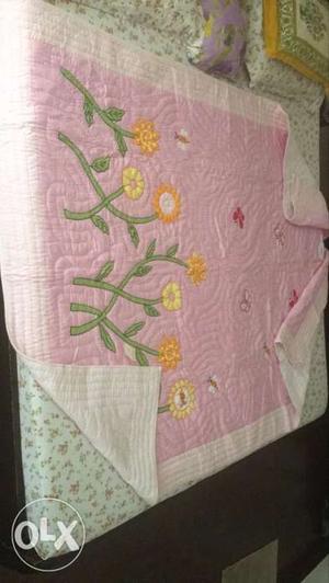 A beautiful pink quilt of size 7.5 feet by 5