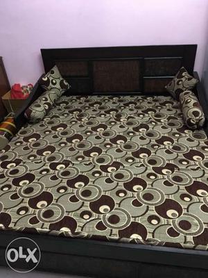 Black Wooden Bed With Multicolored Bedspread