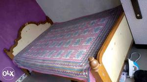 Brown Wooden Bed Frame With Purple Bed Sheet