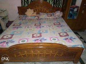 Brown Wooden Bed With Multicolored Floral Bedspread