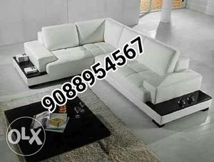 White Leather Sectional Couch And Black Wooden Center Table