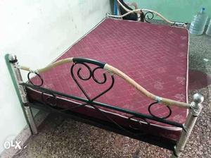 Brown And Black Metal Bed Frame With Purple Floral Mattress