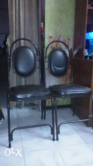 Two Black Metal Framed Leather Padded Chairs