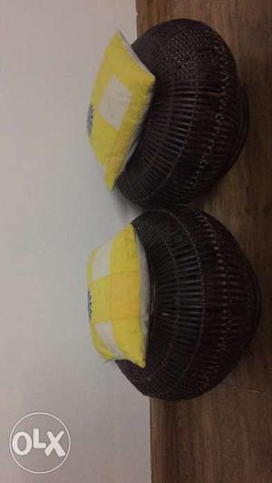 Two Wicker Black Cages With Two Yellow Throw Pillows