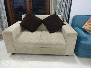 Beige Fabric Loveseat With Brown Throw Pillows