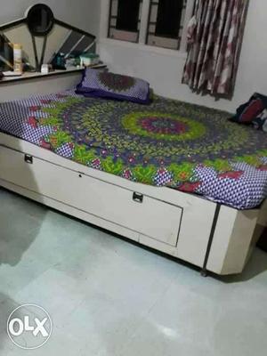 White Wooden Flatbed With Multicolored Bedspread