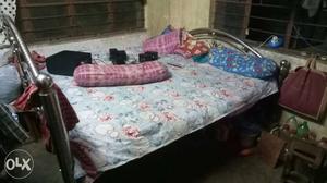 Black Metal Bed With Blue And Multicolored Floral Bedspread