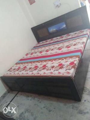Black Wooden Bed With White, Red And Brown Floral Mattress