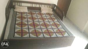Brown Wooden Bed Frame And Black Mattress