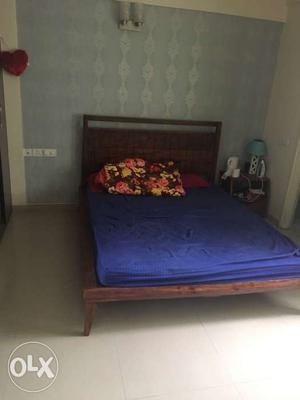 Brown Wooden Bed Frame With Blue Mattress