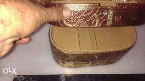 Golden jwellery box contain three apartment. can