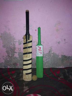 Two Brown And Green Cricket Bats With Ball