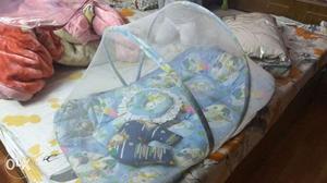 Baby mosquito net with bedding and 2 pillows.