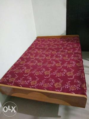 Red Mattress On Brown Wooden Bed Frame