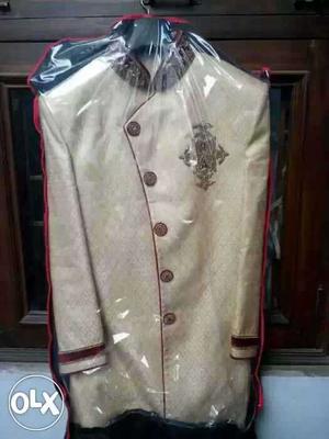 Red and cream sherwani for a hansome groom.