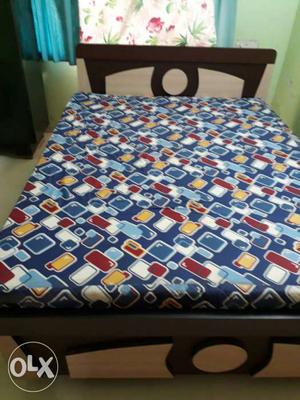 Black And Brown Wooden Bed Frame With Blue And Red Mattress