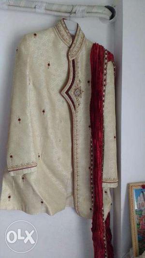 Cream sherwani with red embroidery work