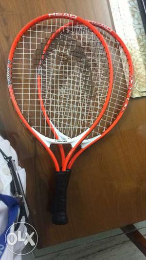 Two Black And Orange Tennis Rackets