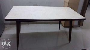 6- seater wooden dining table with laminated top.