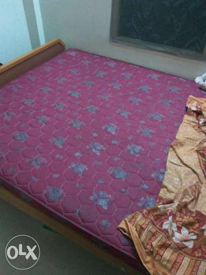 Brown Wooden Bed Frame With Purple Floral Mattress