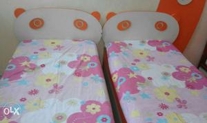 Two Orange-and-white Wooden Panda Bed With Floral Bedspread
