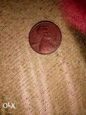 Round Copper-colored one cent Coin in 