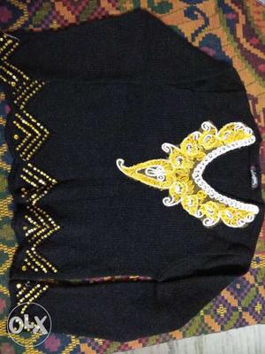 Black sweater with embroidery on neck. Length
