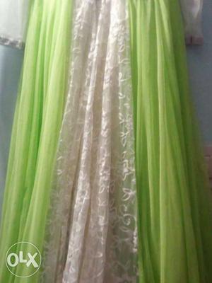 It is a netted gown with green dupatta and stone