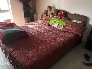 Brown Wooden Bed With Red Mattress And Pillow