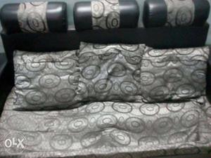 8 month old sofa with 3 pillows black and gray