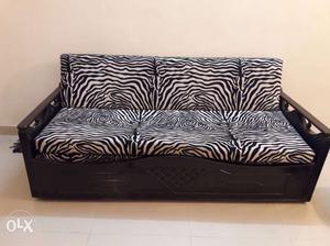 Black And White Zebra Print Sofa with 4 cream cushions.