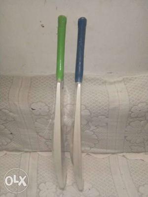Two Brown, Green, And Blue Cricket Bats