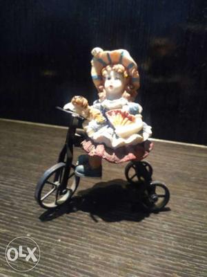 Blue And Brown Dressed Female Riding Trike Ceramic Figurine