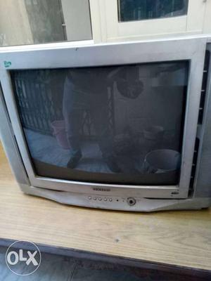 Gray CRT TV With Brown Wooden TV Stand