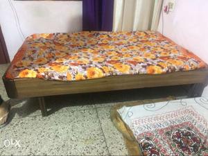 Brown Wooden Bed Frame With Brown Floral Bedspread