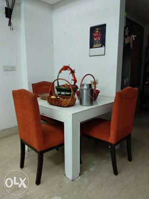 Very smart white solid table with orange 4chairs