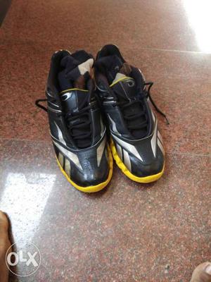 Pair Of Black-silver-and-yellow Reebok Mid-tops with socks