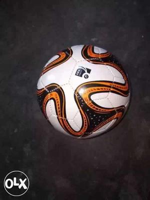 White, Orange, And Black Soccer Ball