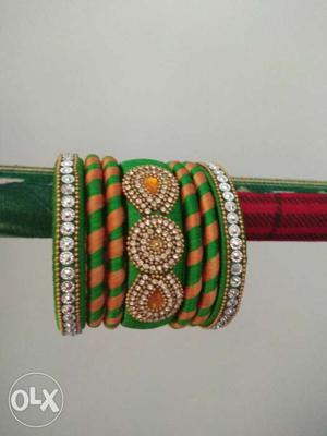 Green, Orange, And Silver-colored Silk Thread Bangles