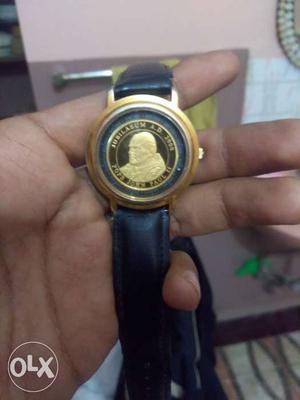 Round Gold-colored Watch With Black Leather Strap. Working