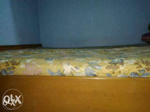 Brown Wooden Bed With Yellow And Beige Floral Spreader