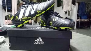 Pair Of Black-green-and-white Adidas Cleats With Box