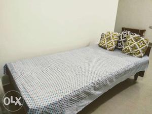 Single wooden bed with matress and four cushions