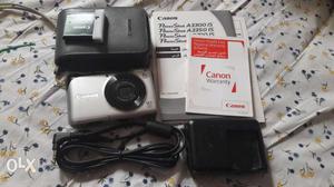 Silver Canon Compact Camera With Charger, Battery, And Case