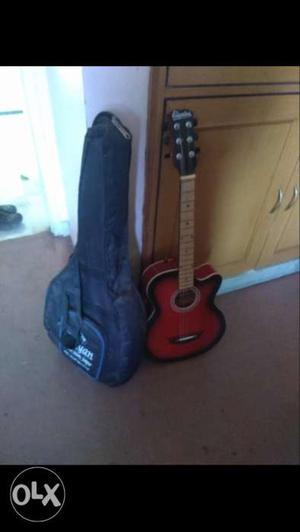 Black And Red Acoustic Guitar With Black Gig Bag