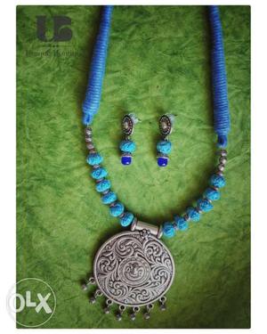 Round Silver-colored Pendant With Blue Necklace And Pair Of