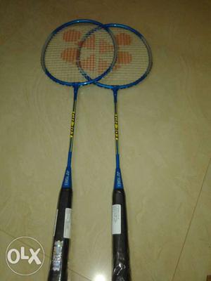 Two Blue-and-yellow Badminton Rackets